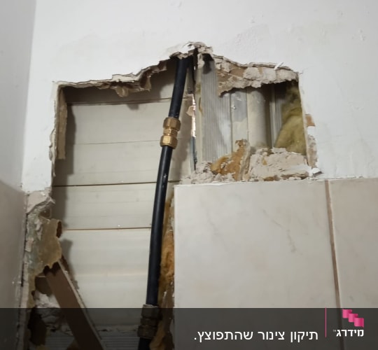 צינור שחור עם מחברים בקיר פתוח